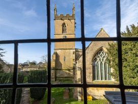 A view of a church tower and trees from a window at Church Alley House Stow-On-The-Wold