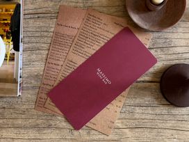 A wine and food menu on a wooden table at Church Alley House Stow-On-The-Wold