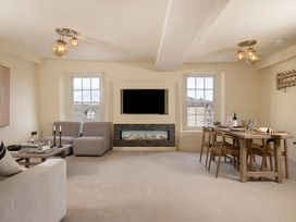 A living room with a sofa and dining table at Church Alley House in Stow-On-The-Wold