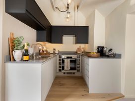 A kitchen with cabinets, sink, appliances, and a countertop at Church Alley House Stow-On-The-Wold