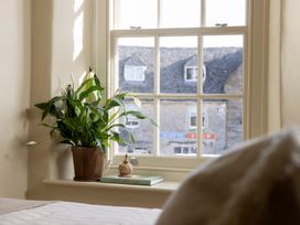 A bedroom window with a plant and a book at Church Alley House Stow-On-The-Wold