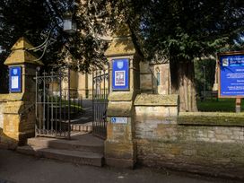 An entrance to St Edward's Church with gates and signs in Stow-On-The-Wold