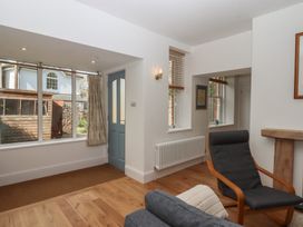 A living room with a chair and a window at Hares Cottage in Torquay