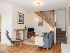A living room with a sofa and television at Hares Cottage in Torquay