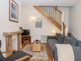 A living room with a sofa and television at Hares Cottage in Torquay