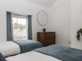 A bedroom with two beds and a dresser at Hares Cottage in Torquay