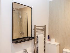 A bathroom with a shower and towel rail at Hares Cottage in Torquay