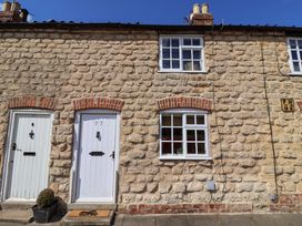 A stone cottage with white doors and windows at The Cook’s Cottage in Malton