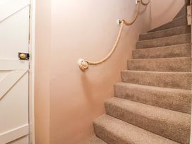 A staircase with carpet and a rope handrail at The Cook’s Cottage in Malton