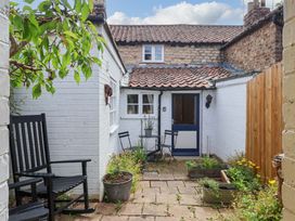 A garden with a table and chairs at The Cook’s Cottage in Malton