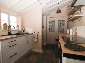 A kitchen with a sink and cabinets at The Cook’s Cottage in Malton