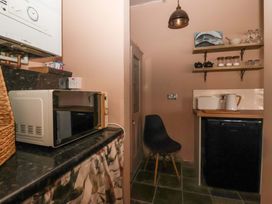 A kitchen with a microwave and refrigerator at The Cook’s Cottage in Malton