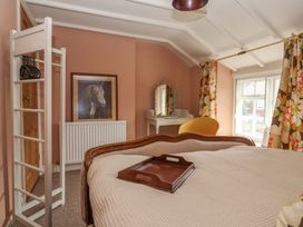 A bedroom with a bed and a wardrobe at The Cook’s Cottage in Malton
