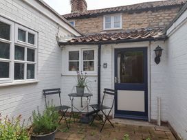 An outdoor area with a table and chairs at The Cook’s Cottage in Malton