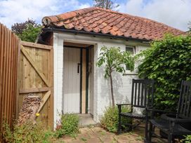 An entrance with wooden door and chairs at The Cook’s Cottage in Malton