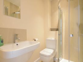A bathroom with a sink, toilet, and shower at Beach Walk in Chathill