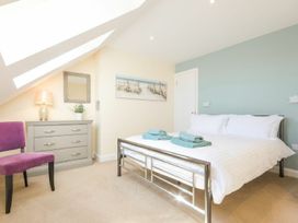 A bedroom with a bed, towels on the bed, and a chest of drawers at Beach Walk in Chathill