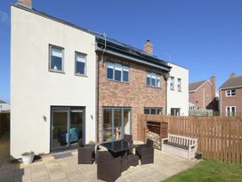 A garden with a patio and furniture at Beach Walk in Chathill