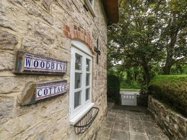 Exterior view of Woodbine Cottage with stone wall and pathway in Weymouth