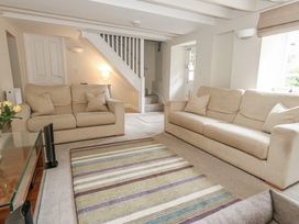 A living room with sofas and rug at Woodbine Cottage in Weymouth