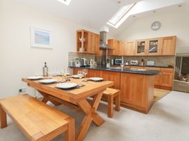 A kitchen with wooden dining table and chairs at Woodbine Cottage in Weymouth