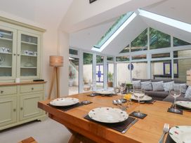 A dining area with a wooden table and chairs at Woodbine Cottage in Weymouth