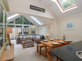 A living room with a sofa and dining table at Woodbine Cottage in Weymouth