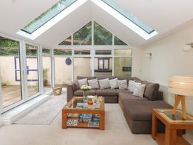 A sunroom with a sofa and coffee table at Woodbine Cottage in Weymouth