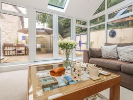 A conservatory with a coffee table and sofa at Woodbine Cottage in Weymouth