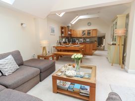 A living room with a kitchen and dining table at Woodbine Cottage in Weymouth