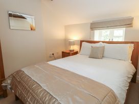 A bedroom with a bed and a bedside table at Woodbine Cottage in Weymouth