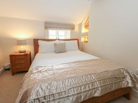 A bedroom with a bed and bedside table at Woodbine Cottage in Weymouth