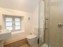 A bathroom with a shower, sink, and toilet at Woodbine Cottage in Weymouth