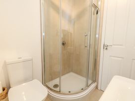 A bathroom with a shower and a toilet at Woodbine Cottage in Weymouth