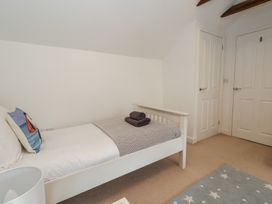 A bedroom with a bed and two doors at Woodbine Cottage Weymouth