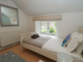 A bedroom with a bed and a window at Woodbine Cottage in Weymouth