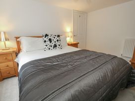 A bedroom with a bed and nightstands at Woodbine Cottage in Weymouth