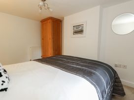 A bedroom with a bed and wardrobe at Woodbine Cottage in Weymouth