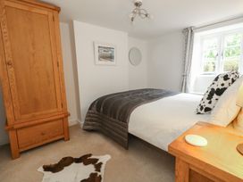 A bedroom with bed and wardrobe at Woodbine Cottage in Weymouth
