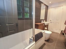 A bathroom with a bathtub and sink at Woodbine Cottage in Weymouth