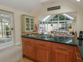 A kitchen with an island and glass doors at Woodbine Cottage in Weymouth