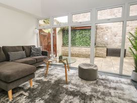 A living room with a glass table and sofa at Woodbine Cottage in Weymouth