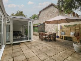 A garden with a dining area and seating at Woodbine Cottage in Weymouth