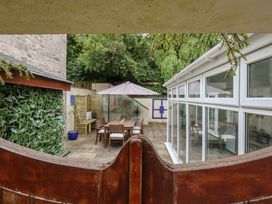 A garden with a patio set and an umbrella at Woodbine Cottage in Weymouth