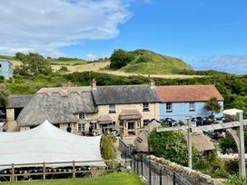 An outdoor area with a pub and seating at Woodbine Cottage in Osmington