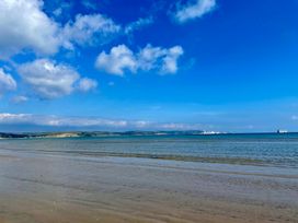 A beach with water and clouds at Woodbine Cottage in Osmington