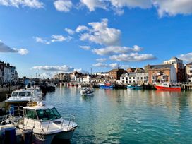 A harbor with boats and buildings at Woodbine Cottage in Osmington