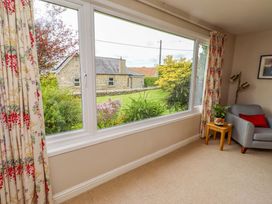 A living room with a window overlooking a garden at Campden in Rennington near Embleton