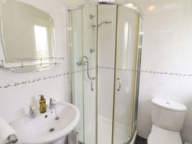 A bathroom with a shower, sink, and toilet at Campden in Rennington near Embleton