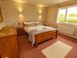 A bedroom with a bed and dresser at Campden in Rennington near Embleton